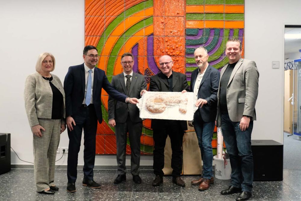 Symbolische Schlüsselübergabe mit Gebäck Schlüssel